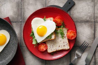 Lezzetli kızarmış yumurta, tost, domates ve arkaplanda roka karışımı.