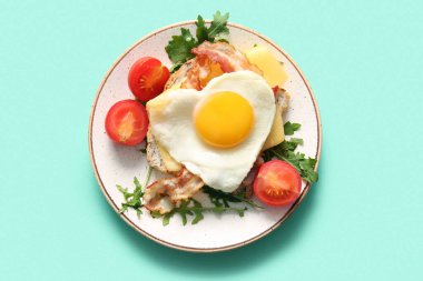 Lezzetli kızarmış yumurta, domates ve turkuaz arkaplanda roka.