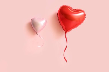Pembe arka planda kalp şeklinde hava balonları. Sevgililer Günü kutlaması