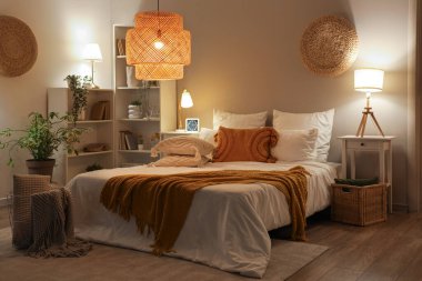 Rahat yatak odası, battaniye ve geceleri parlayan lambalar.