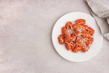 Beyaz arka planda peynirli lezzetli bir gnocchi tabağı.