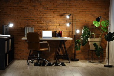 Karanlık ofis, iş yeri, boş laptop ve geceleri parlayan lambalar.