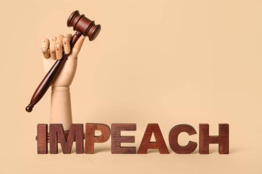 Hakim tokmağı ve bej arka planda IMPEACH sözcüğüyle tahta el