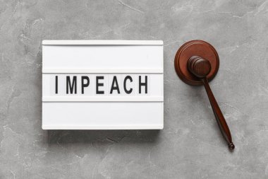Judge gavel and board with word IMPEACH on grey grunge background