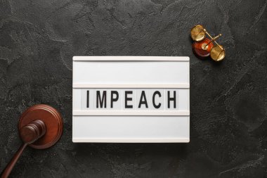 IMPEACH yazılı pano, yargıç tokmağı ve siyah grunge arka planda adalet terazisi