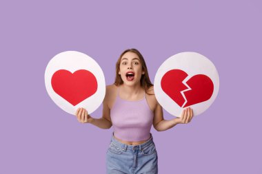 Güzel, genç, şok olmuş, kalbi mor arkaplandaki ikonları seven ve sevmeyen bir kadın.