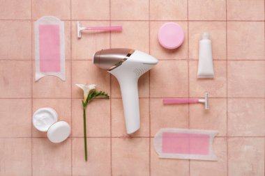 Balmumu şeritleri, jiletleri ve pembe fayanslı kozmetik ürünleriyle modern fotoepilatör.