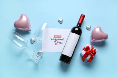 Gözlüklü bir şişe şarap, mavi arka planda kartpostal ve dekor. Sevgililer Günü kutlaması