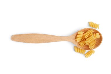 Ahşap kaşık ve beyaz arka planda pişmemiş fusilli makarna.
