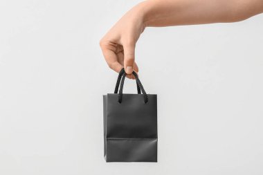 Beyaz arka planda küçük bir alışveriş torbası olan bir kadın. Sevgililer Günü kutlaması