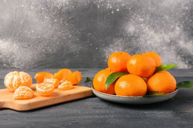 Gri ahşap masada lezzetli mandalinalı tabak ve yemek.