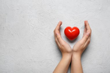 Beyaz arka planda kırmızı kalpli kadın elleri