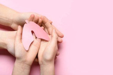 Pembe arka planda kağıt ciğerli kadın ve çocuğun elleri