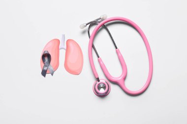 Kurdeleli kağıt ciğerler ve gri arka planda steteskop.