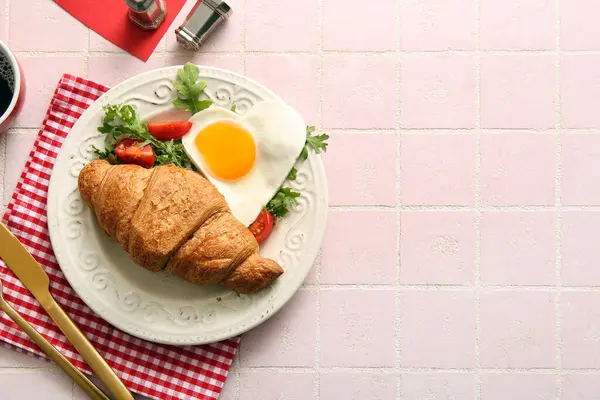 Lezzetli kızarmış yumurta, kruvasan, domates ve arkaplanda roka.