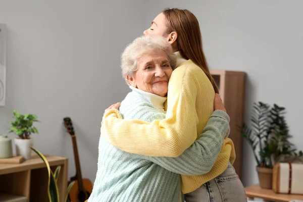 Büyük kadın torununa evde sarılıyor.