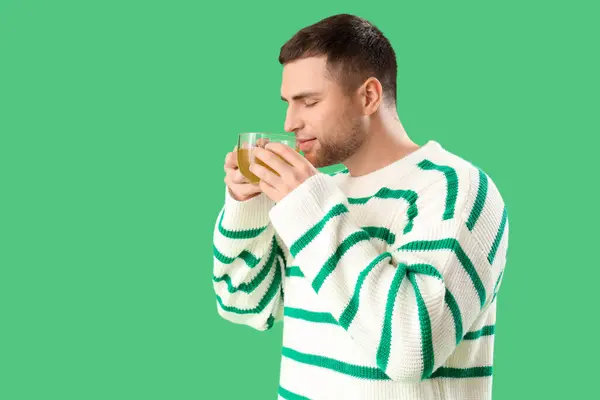 Yeşil Arka Planda Limon Çayı Içen Genç Adam — Stok fotoğraf