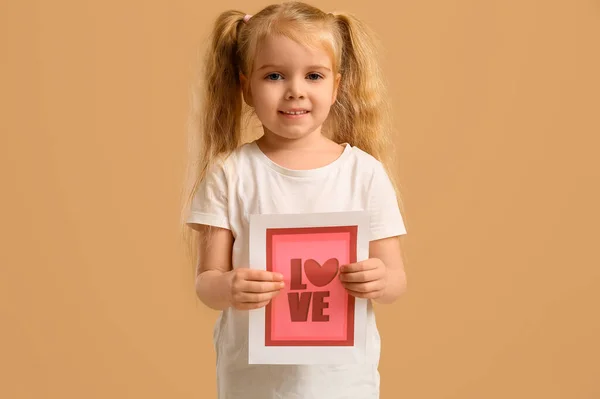Симпатична Дівчинка Тримає Вітальну Листівку Словом Любов Серце Бежевому Тлі — стокове фото