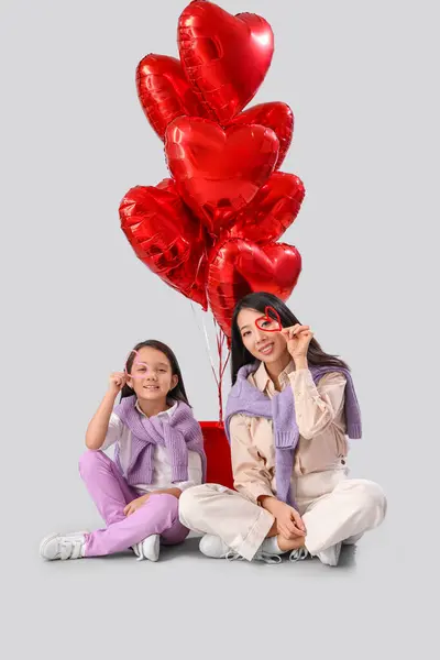 有趣的亚洲女人和她的小女儿拿着装饰的心脏 用白色背景的气球 情人节庆祝活动 — 图库照片