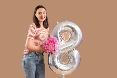 Üzerinde pembe kasımpatı çiçekleri ve kahverengi arka planda şekil 8 şeklinde gümüş hava balonu olan güzel bir kadın. Uluslararası Kadınlar Günü
