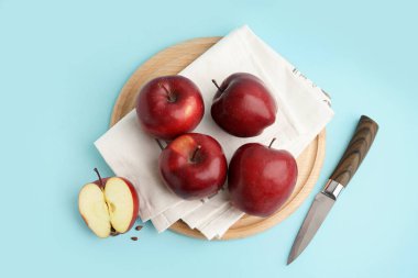 Mavi arka planda taze kırmızı elmalı ahşap tahta.