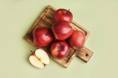 Yeşil arka planda taze kırmızı elmalı ahşap tahta.