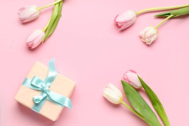 Güzel lalelerden yapılmış çerçeve ve pembe arka planda hediye kutusu. Uluslararası Kadınlar Günü