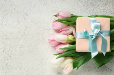 Bir buket güzel lale ve beyaz arka planda hediye kutusu. Uluslararası Kadınlar Günü