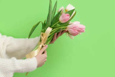 Yeşil arka planda bir buket güzel lale olan kadın elleri. Uluslararası Kadınlar Günü