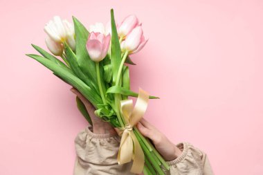 Pembe arka planda bir buket güzel lalesi olan kadın elleri. Uluslararası Kadınlar Günü