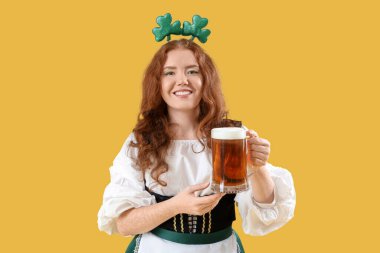 Sarı arka planda biralı genç İrlandalı garson. Aziz Patrick Günü kutlaması