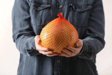 Olgun pomelo tutan adam, yakın plan.