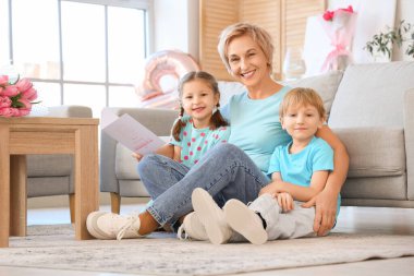 Evde tebrik kartı olan küçük çocuklar ve büyükanneleri. Uluslararası Kadınlar Günü