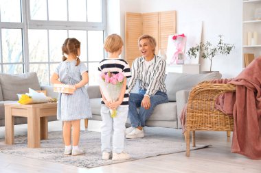 Küçük çocuklar evde büyükannelerini hediyelerle selamlıyorlar. Uluslararası Kadınlar Günü