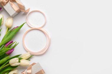 Şekil 8, hediye kutuları ve gri arka planda güzel laleleri olan bir kurdele. Uluslararası Kadınlar Günü