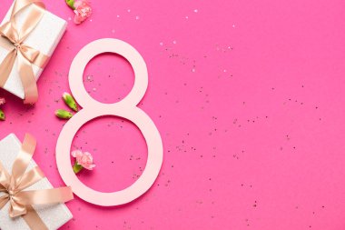 Hediye kutuları ve pembe arka planda güzel çiçekleri olan 8 numara. Uluslararası Kadınlar Günü
