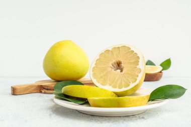 Tabak ve ahşap tahta, beyaz arka planda taze nar meyveleri.