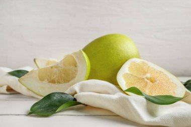 Taze meyve ve yapraklar beyaz ahşap masada.