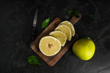 Siyah arka planda taze nar meyvesi kesilmiş ahşap tahta.