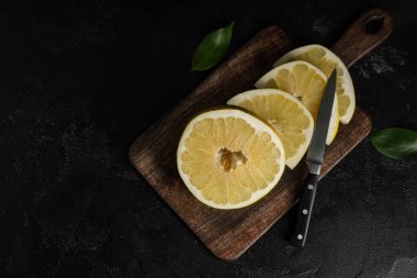 Siyah arka planda taze nar meyvesi kesilmiş ahşap tahta.