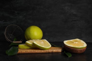 Tahta tahtada siyah arka planda taze nar meyvesi parçaları var.