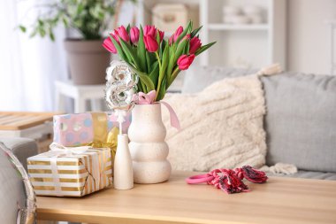 Laleli vazo, hediye kutuları ve masadaki sekizinci şekil hava balonu.