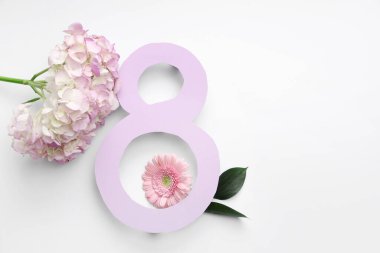 Beyaz arka planda güzel gerbera ve ortanca çiçekleri olan kağıttan yapılmış 8 figür. Uluslararası Kadınlar Günü