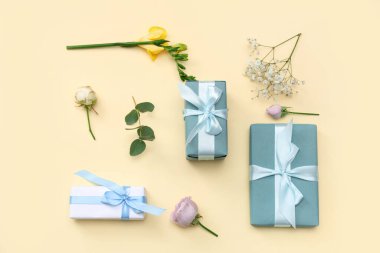 Hediye kutuları ve sarı arka planda farklı güzel çiçekler. Uluslararası Kadınlar Günü