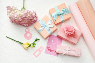 Hediye kutuları ve beyaz arka planda güzel çiçekleri olan kağıttan yapılmış 8 figür. Uluslararası Kadınlar Günü