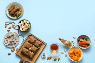 Renkli arkaplan üzerine lezzetli Doğu tatlıları, Aladdin lambası ve Ramazan için tasbih kompozisyonu