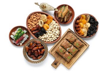 Beyaz arka planda geleneksel Doğu tatlıları, Aladdin lambası ve Ramazan için tasbih kompozisyonu