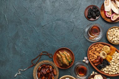 Ramazan için geleneksel Doğu tatlıları, çay ve tasbih içeren koyu renk arkaplan kompozisyonu
