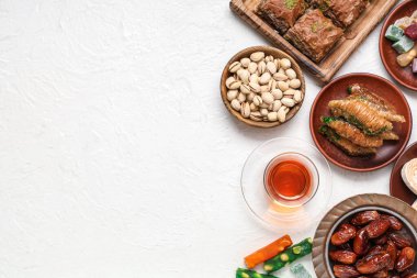 Hafif arkaplanda geleneksel Doğu tatlıları ve Ramazan ayı için çay kompozisyonu