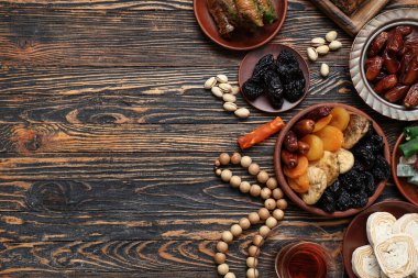 Ahşap zemin üzerinde geleneksel Doğu tatlıları ve Ramazan için tasbih kompozisyonu